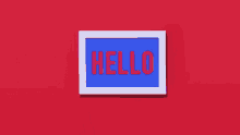 a person is pointing at a sign that says `` hello '' .