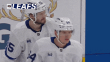 two hockey players are standing next to each other with the word leafs on the screen