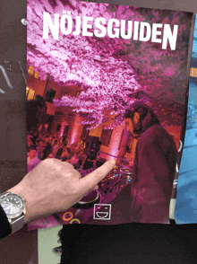 a person pointing at a poster that says nojesguiden on it