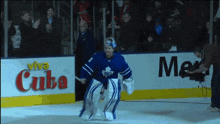 a hockey player on the ice in front of a viva cuba sign