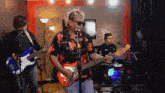 a man playing a guitar and singing into a microphone while another man plays drums
