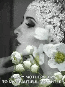 a woman in a hat is holding a bouquet of white flowers in her hand .