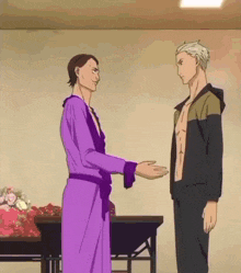 a man in a purple robe shakes hands with a man in a black jacket