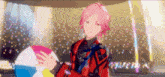a person with pink hair is holding a beach ball in their hands .
