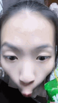 a close up of a woman making a funny face with a bag of chips in the background
