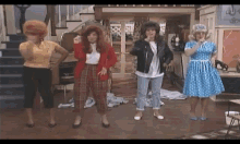 a group of women are standing in a room dancing together .