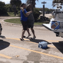 two men hugging in a parking lot with a pepsi box in the back of a truck