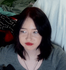 a close up of a woman 's face with a gray shirt on