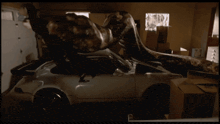 a car is parked in a garage with boxes on the ground