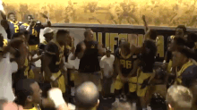 a group of football players are dancing in front of a california banner