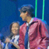 a man in a red jacket stands next to a woman