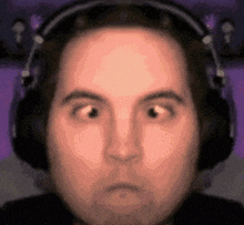 a man is wearing headphones and making a funny face .
