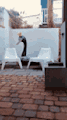 a blurry picture of a patio with chairs and a person on a skateboard