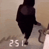 a person is walking down a set of stairs with the time 2:51 .