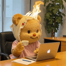 a teddy bear sitting at a desk with an apple laptop and a cup of coffee