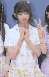 a girl wearing a white shirt with flowers on it
