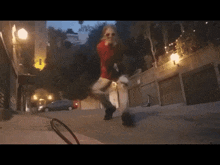 a woman in a red dress and sunglasses is running down a street
