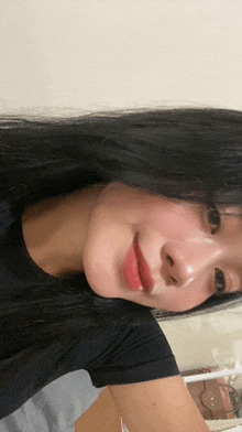 a woman with long black hair and red lips is smiling