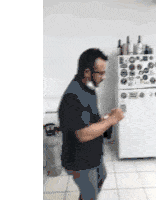 a man is standing in front of a refrigerator in a kitchen .