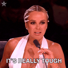 a woman speaking into a microphone with the words it 's really tough written below her