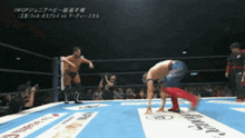 two wrestlers are in a ring with a banner that says ' iwgp ' on it