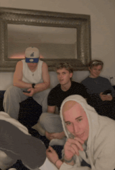 a man wearing a new york yankees hat sits next to another man