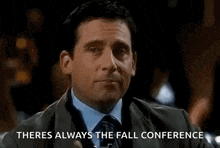 a man in a suit and tie is holding a glass of whiskey and says there is always the fall conference .
