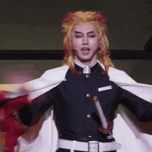 a man in a costume is holding a sword and a cape