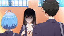 a boy and two girls are standing in front of a wall