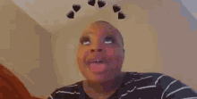 a woman with hearts on her head is wearing a black and white striped shirt .