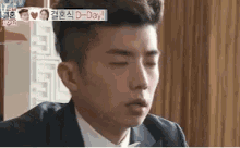 a man in a suit and tie is sitting at a table with his eyes closed