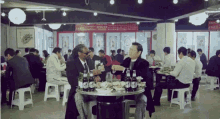 two men sitting at a table with bottles of beer on it