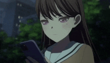a girl with purple eyes is holding a cell phone and looking at it .