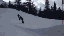a person is riding a snowboard down a snow covered slope .