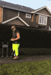 a man riding a unicycle in front of a house with the number 4005 on it