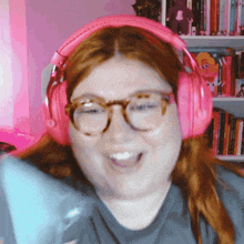 a woman wearing pink headphones and glasses is making a funny face