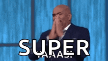 a bald man in a suit and tie is clapping his hands in front of the word super