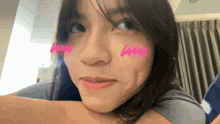 a close up of a woman 's face with a pink heart on her cheeks