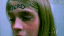 a girl with the word etero painted on her forehead