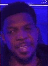 a close up of a man 's face with a beard in a dark room .
