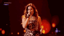 a woman in a leopard print dress sings into a microphone on a tv screen that says 1 hd