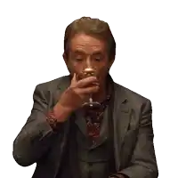 a man in a suit drinking from a glass
