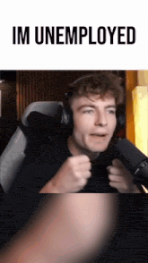 a man wearing headphones is sitting in front of a microphone with the words im unemployed above him