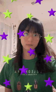 a woman wearing glasses and a green shirt that says " aa " on it