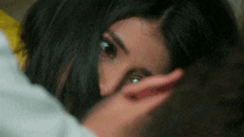 a close up of a woman covering her face with her hands .
