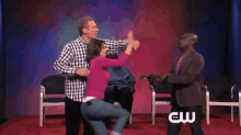 a man and a woman are dancing on a stage with the cw logo in the background