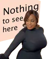 a woman in a black top stands in front of a sign that says nothing to see here
