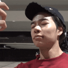 a man wearing a baseball cap and a red shirt is being sprayed with something