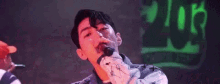 a man is holding a microphone in his hand and making a funny face .