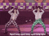 two men are dancing on a stage and the words ngad tang ngad tang ngad tang ngad are visible